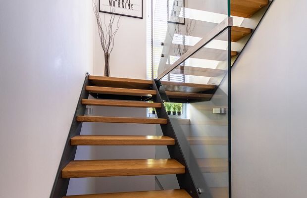 STREIF Innenraum Treppe mit offenen Holzstufen, Metallkonstruktion und Glasgeländer in modernem Flur