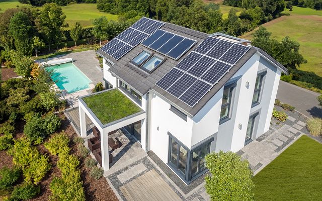 Fertighaus Stadtvilla zweigeschossig mit Satteldach, weiße Putzfassade, große Fenster, Solardach, Terrasse, Pool, Garten