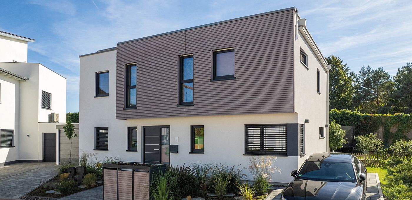 Fertighaus Stadtvilla zweigeschossig mit Flachdach, weißer Putzfassade, grauer Akzentfassade und Einfahrt