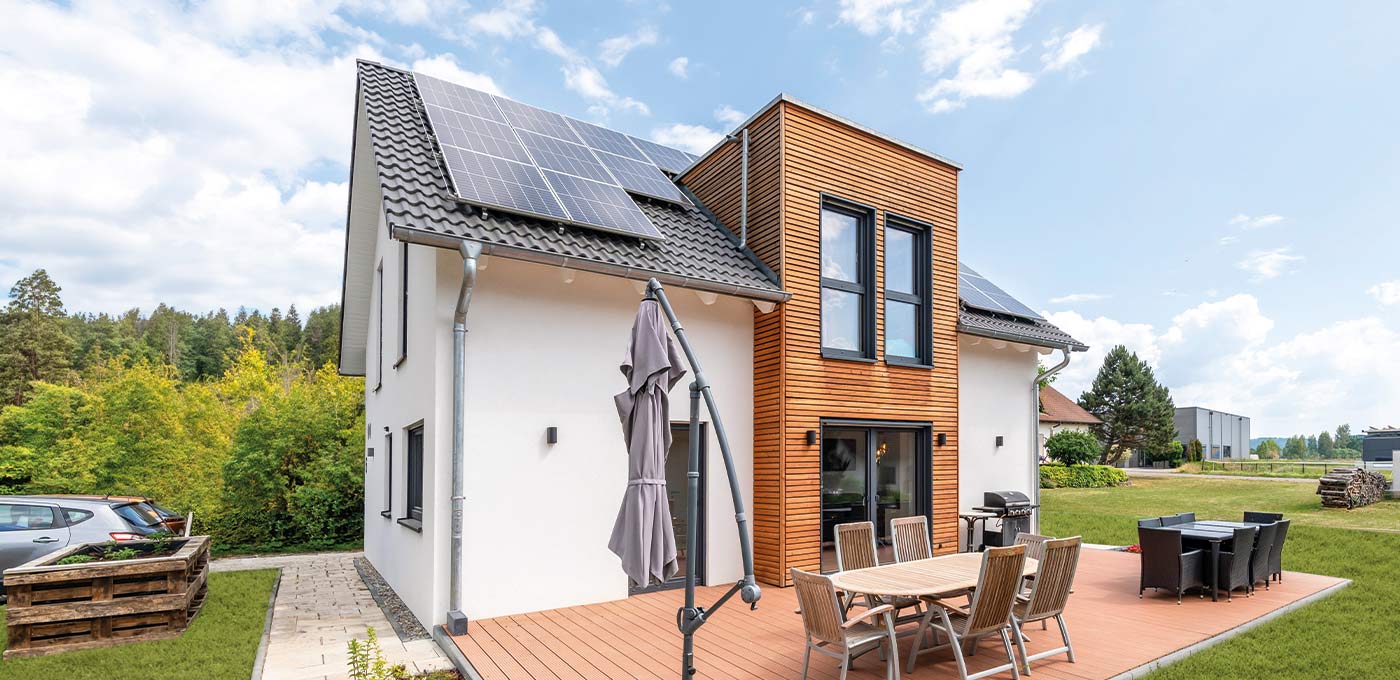 Fertighaus Stadtvilla zweigeschossig mit Satteldach, weißer Putzfassade, Holzakzent, Terrasse und Garten