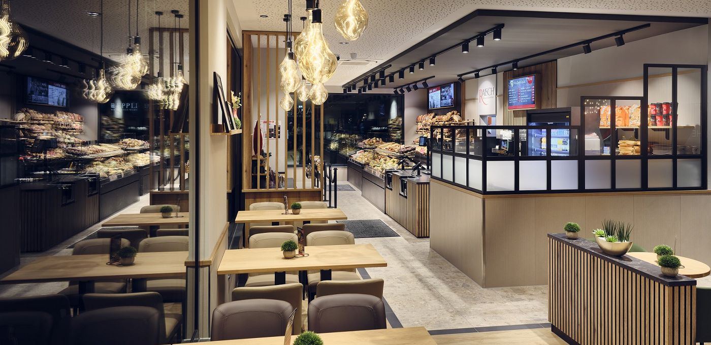 STREIF Innenraum Bäckerei mit Sitzbereich, Verkaufstheke, Brotregalen und moderner Beleuchtung
