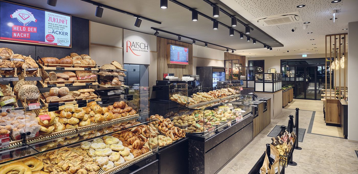 STREIF Innenraum Bakery Cube Bäckerei Verkaufsraum mit Theke, vielfältiger Backwarenauslage, Brotregalen und Kassenzone